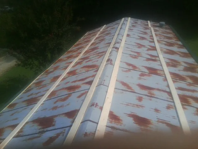 Rusted metal roof panels with new wood purlins before replacement — Storm Damage Roof Repair in Plainville by Roofing Brothers